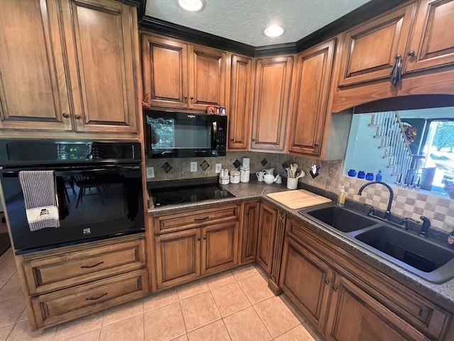 kitchen with backsplash, a sink, a textured ceiling, light tile patterned floors, and black appliances