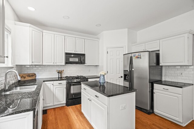 513 Cold Stream Pl, Nashville, TN 37221 - kitchen featuring white cabinetry, a center island, a sink, light wood finished floors, and black appliances