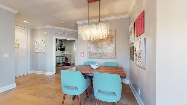 dining area featuring crown molding, baseboards, light wood-style floors, recessed lighting, and an inviting chandelier