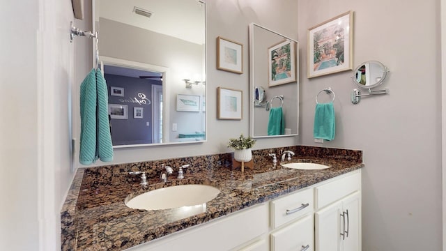 bathroom with visible vents, a sink, and double vanity