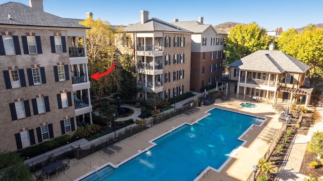 community pool with a patio and fence