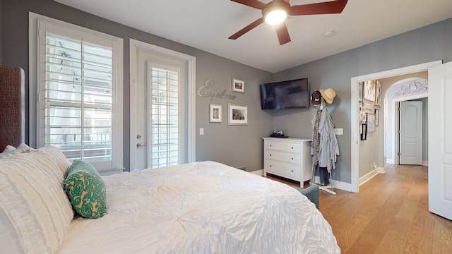 bedroom with a ceiling fan, light wood-style flooring, and baseboards
