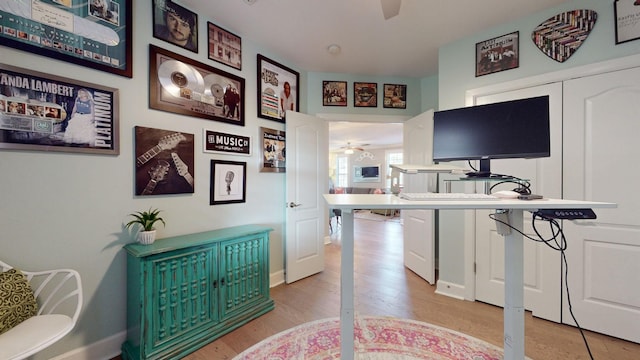 office with light wood finished floors and ceiling fan