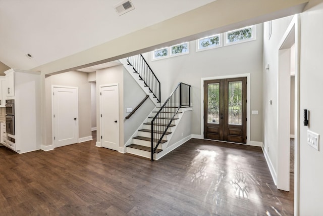 foyer featuring french doors, stairway, dark wood-style floors, baseboards, and visible vents