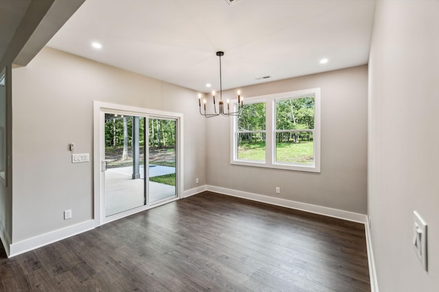 empty room featuring dark wood-style flooring, a notable chandelier, and baseboards