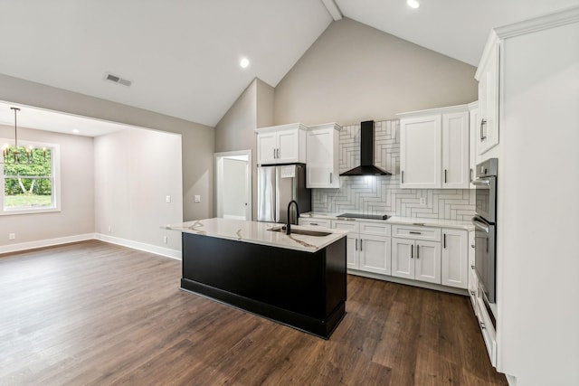 kitchen with a sink, stainless steel appliances, wall chimney range hood, visible vents, and dark wood-type flooring