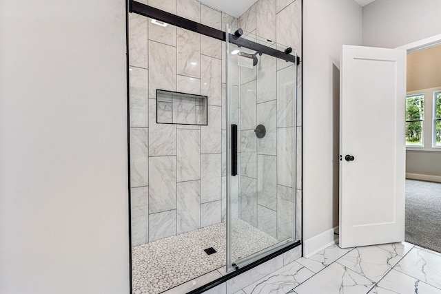 bathroom with baseboards, marble finish floor, and a shower stall