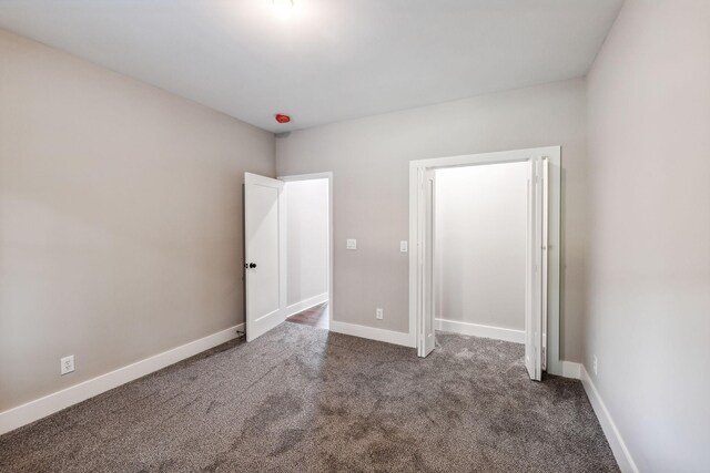 unfurnished bedroom with baseboards and carpet flooring
