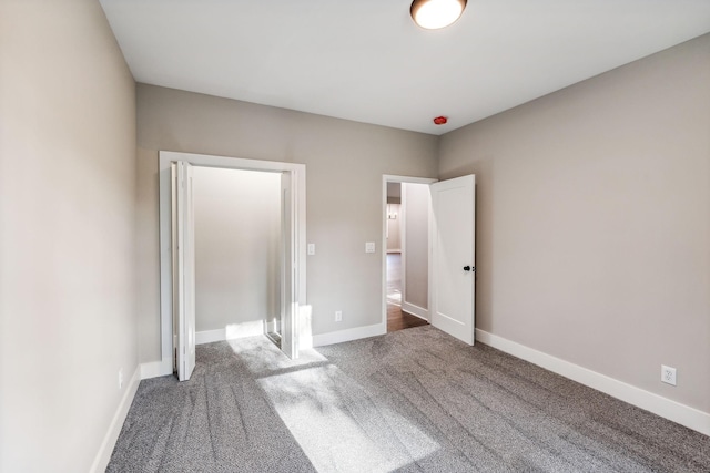 unfurnished bedroom featuring carpet and baseboards