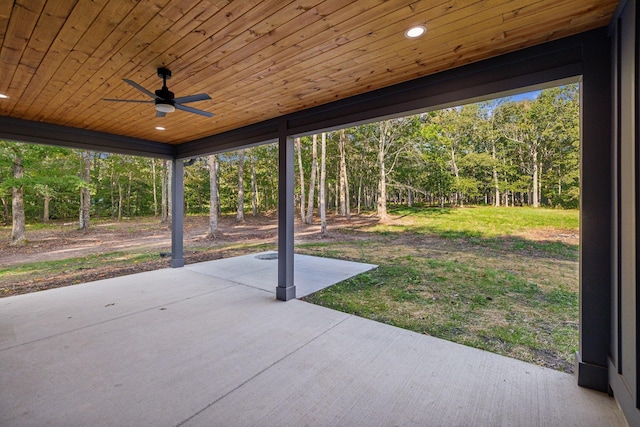view of patio featuring a view of trees and ceiling fan