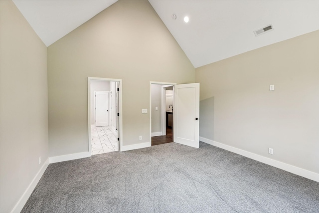unfurnished bedroom with baseboards, visible vents, high vaulted ceiling, and carpet flooring
