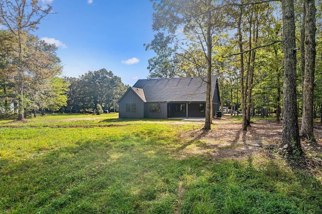 exterior space featuring a lawn and roof with shingles