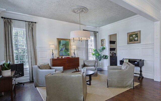 living room with ornamental molding, a decorative wall, an ornate ceiling, and wood finished floors