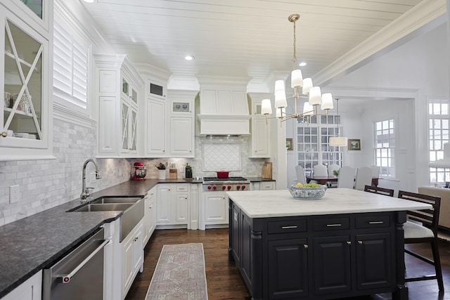 kitchen with dark cabinets, white cabinets, a chandelier, and appliances with stainless steel finishes