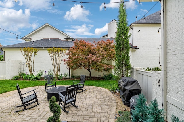 view of patio with a fire pit, a grill, and fence