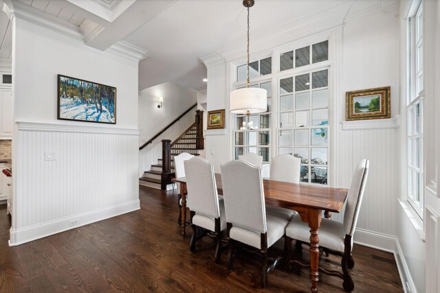 dining area with stairway, dark wood-style floors, ornamental molding, and wainscoting