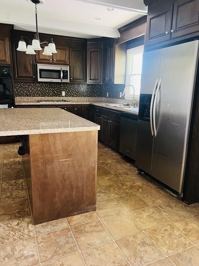 kitchen featuring backsplash, beamed ceiling, stainless steel appliances, pendant lighting, and a sink