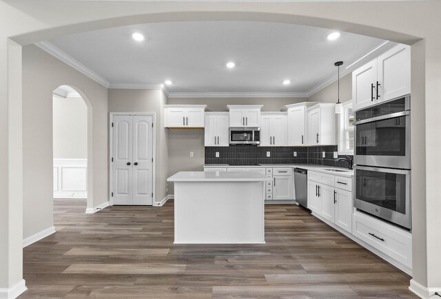 2539 Rafiki Dr, Clarksville, TN 37042 - kitchen with appliances with stainless steel finishes, a center island, ornamental molding, white cabinetry, and recessed lighting
