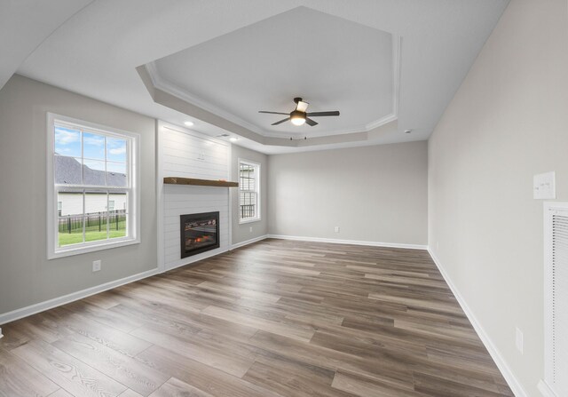 2539 Rafiki Dr, Clarksville, TN 37042 - unfurnished living room featuring a raised ceiling, a ceiling fan, wood finished floors, a fireplace, and baseboards