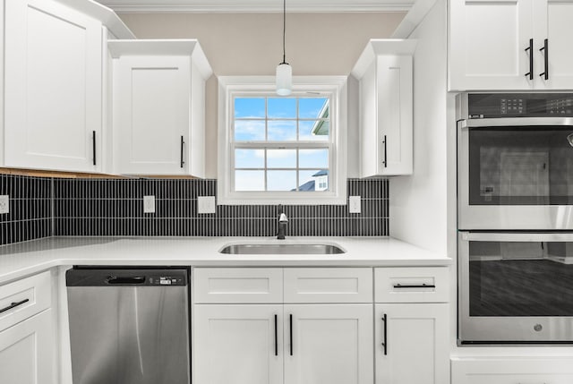 2539 Rafiki Dr, Clarksville, TN 37042 - kitchen with appliances with stainless steel finishes, a sink, white cabinets, light countertops, and ornamental molding