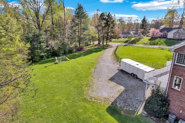view of property's community featuring a yard and fence