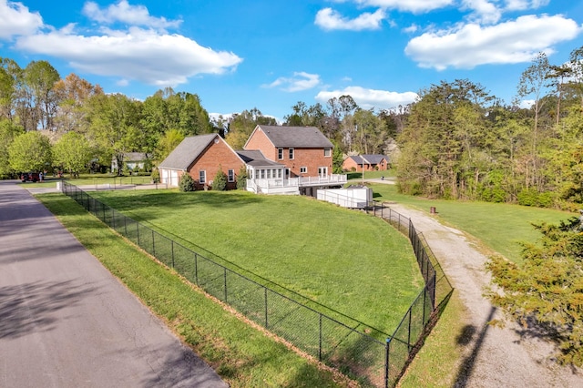 exterior space featuring a front lawn, brick siding, and fence