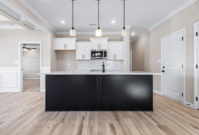 2531 Rafiki Dr, Clarksville, TN 37042 - kitchen featuring white cabinetry, light countertops, stainless steel microwave, an island with sink, and a ceiling fan
