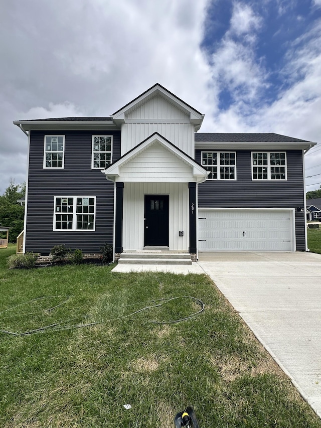 view of front facade featuring concrete driveway, a front lawn, and board and batten siding