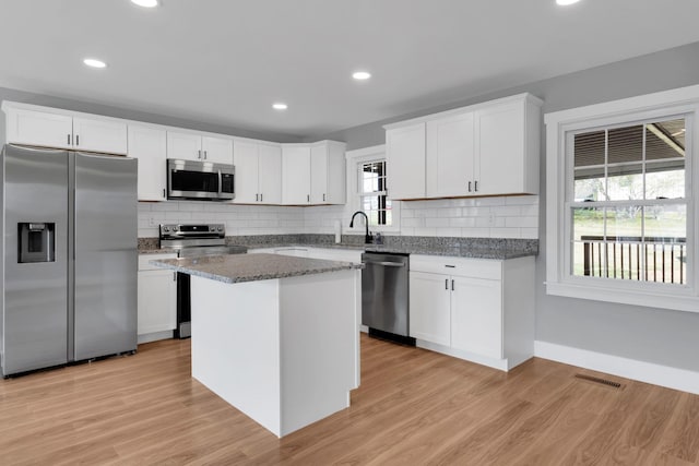 kitchen featuring tasteful backsplash, light wood-style flooring, a sink, and stainless steel appliances