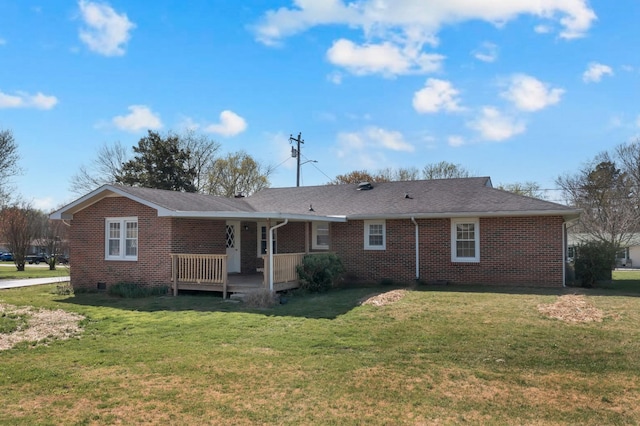 rear view of property featuring covered porch, brick siding, and a yard