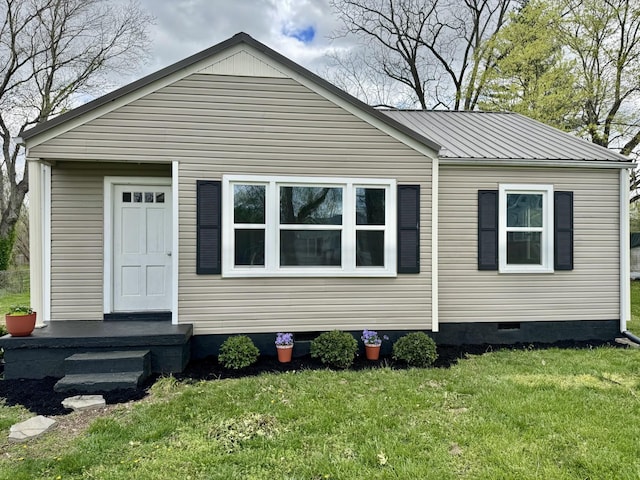 view of front facade with a front yard, crawl space, and metal roof