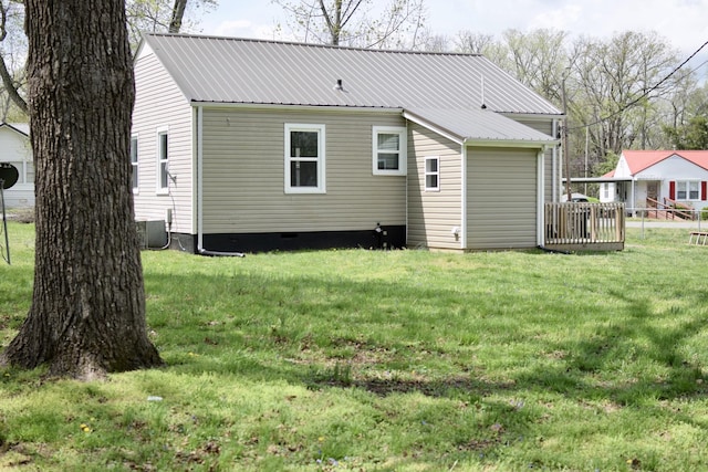 back of house with central air condition unit, fence, metal roof, crawl space, and a yard