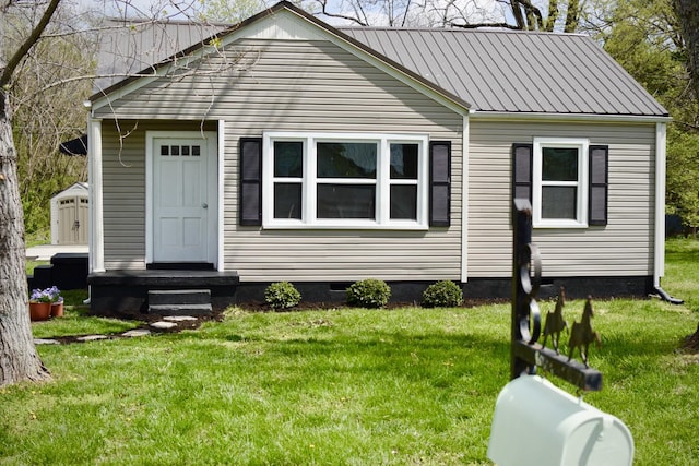 bungalow-style home featuring a front yard, crawl space, and metal roof