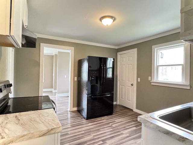 kitchen with black fridge with ice dispenser, light countertops, baseboards, and stainless steel range with electric stovetop