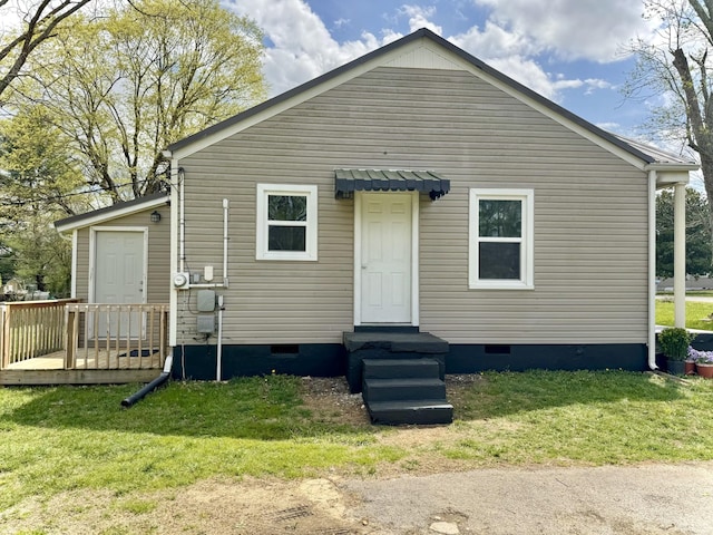 rear view of house featuring crawl space and a lawn