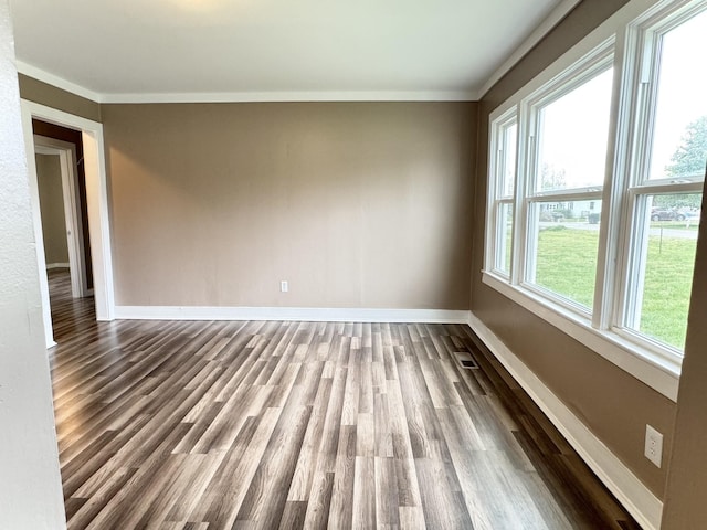 unfurnished room with baseboards, dark wood-style flooring, and ornamental molding