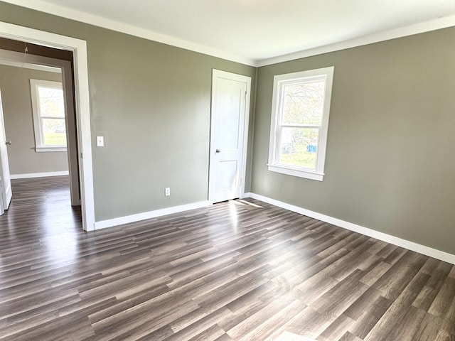 unfurnished bedroom featuring baseboards, dark wood-style floors, multiple windows, and a closet
