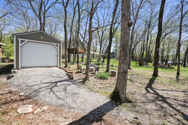 view of yard featuring an outbuilding, driveway, and a detached garage