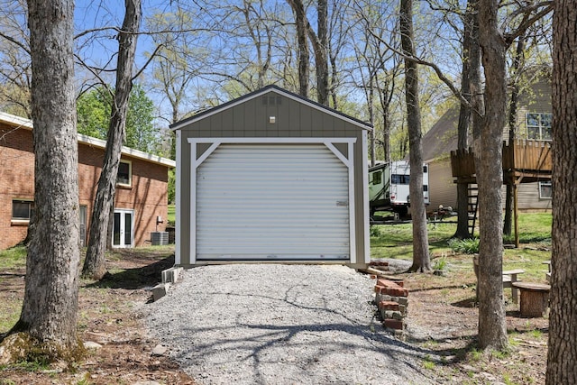 detached garage featuring gravel driveway and cooling unit