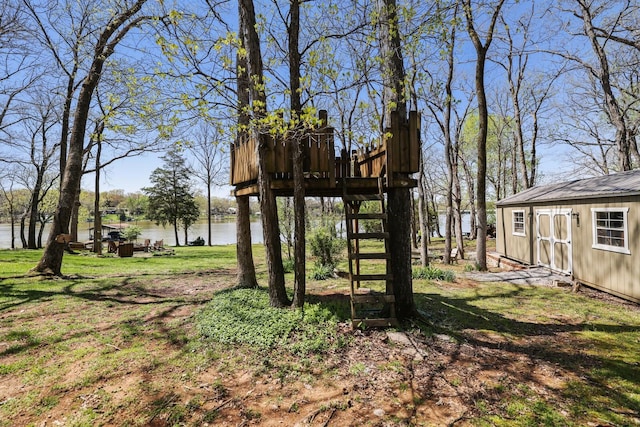 view of yard featuring a water view, a storage shed, and an outdoor structure