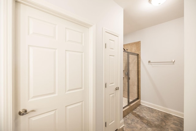 full bath with baseboards and a shower stall