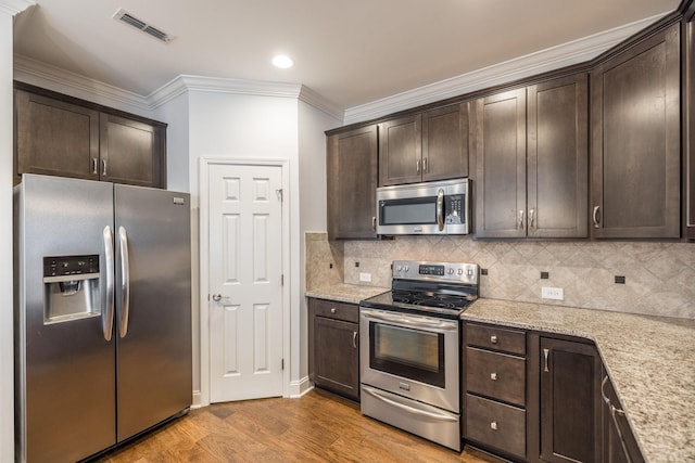 kitchen featuring light wood-type flooring, dark brown cabinets, stainless steel appliances, and visible vents