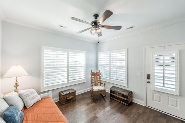 interior space featuring a ceiling fan, dark wood-type flooring, baseboards, visible vents, and ornamental molding