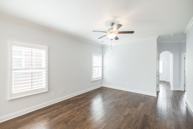 spare room with crown molding, baseboards, dark wood finished floors, arched walkways, and ceiling fan
