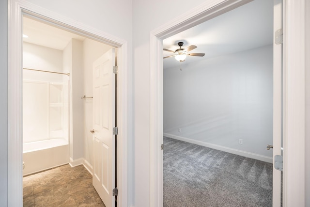 hall with baseboards and carpet