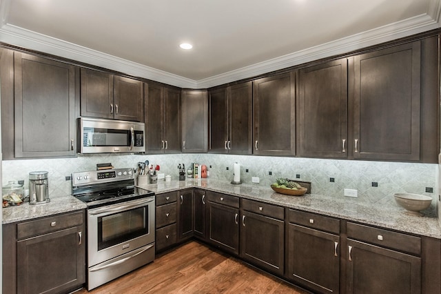 kitchen with light stone countertops, dark wood-style flooring, stainless steel appliances, decorative backsplash, and dark brown cabinets