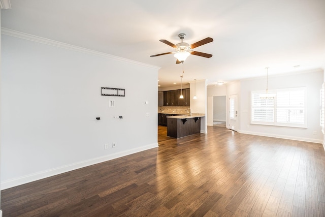 unfurnished living room featuring baseboards, crown molding, ceiling fan, and dark wood-style flooring
