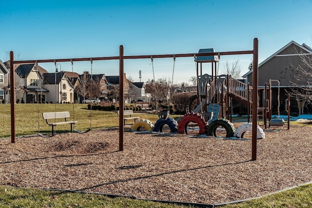 communal playground featuring a residential view and a yard