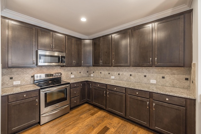 kitchen with tasteful backsplash, dark wood-style flooring, stainless steel appliances, light stone counters, and dark brown cabinets