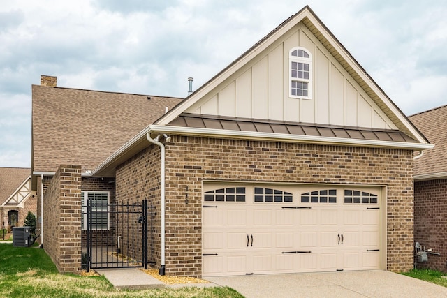 view of front of home with board and batten siding, brick siding, concrete driveway, and a standing seam roof